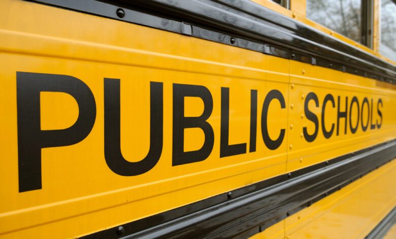 School bus background. Large "Public Schools" sign, black letters on yellow side panel