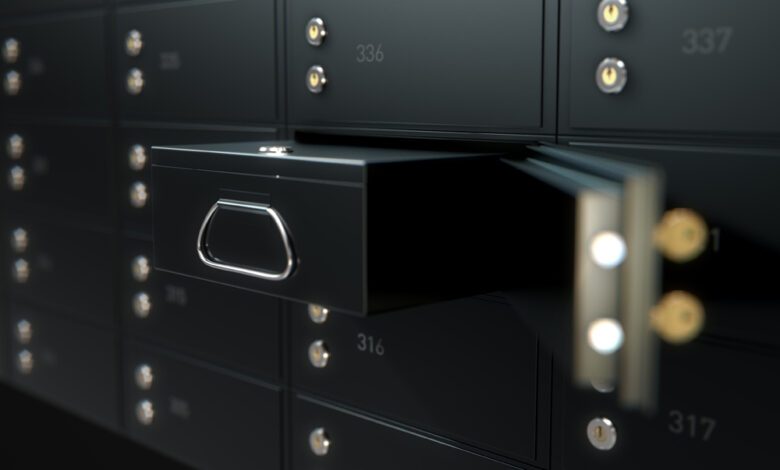 A 3D render of a wall of black numbered metal safe deposit boxes in a vault with one opened revealing its contents inside